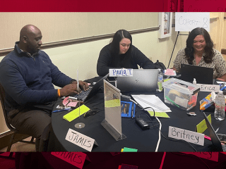 IMPACT fellows (from left to right) James Copeland, Paula Thiel and Erica Box attend a professional development training in Little Rock and sit at a table as a group.