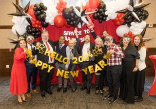 College of Education and Health Professions leadership holds a Happy New Year 2024 sign at the Service to Arkansas Celebration, held in December 2023.