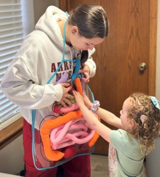 Katie Spallo, a senior in the Eleanor Mann School of Nursing, works with a child during SPARK Day.